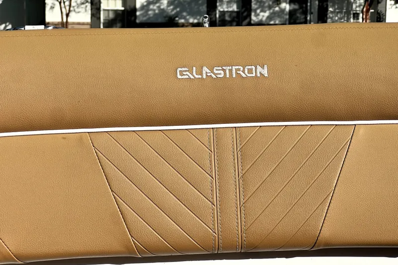Slide: The Image of Close-up of 2019 Glastron GTD 220 boat seat with tan upholstery and logo. - 59