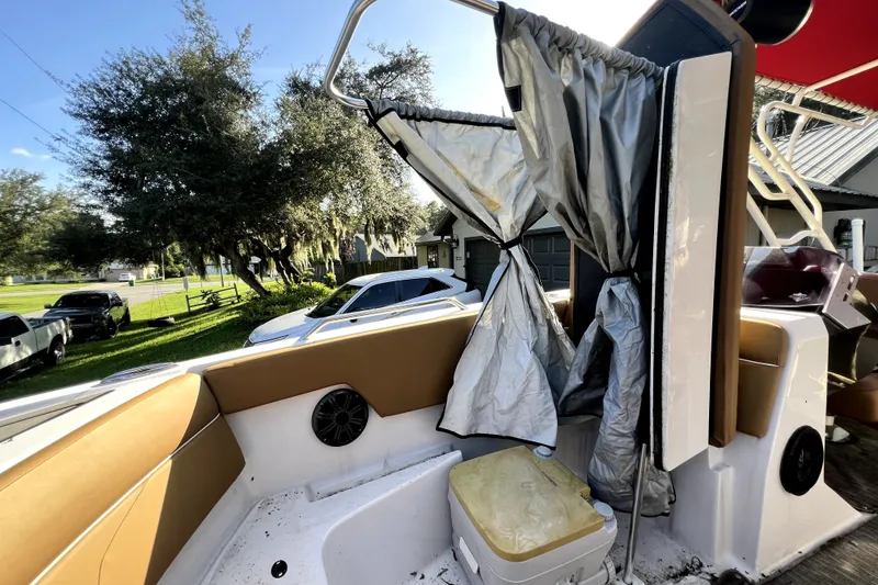 Slide: The Image of 2019 Glastron GTD 220 boat interior with seating and storage, parked outdoors. - 45