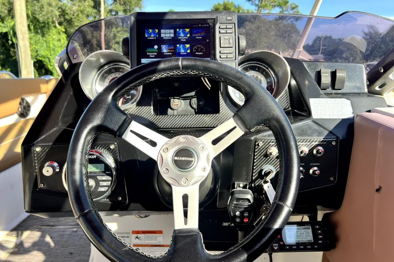 Slide: The Image of Cockpit of 2019 Glastron GTD 220 boat with steering wheel and control panel. - 30