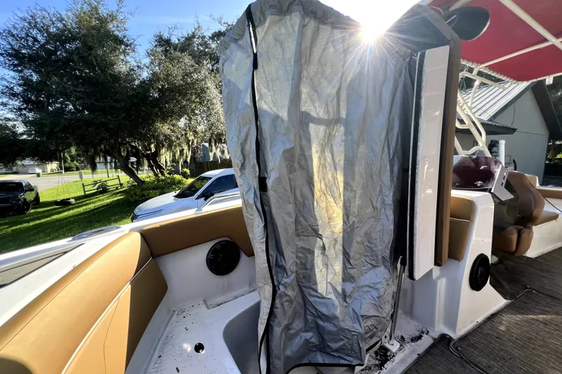 Slide: The Image of 2019 Glastron GTD 220 boat interior with sunlit tarp and seating area. - 46
