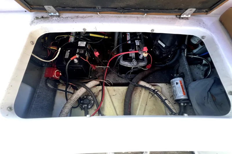 Slide: The Image of 2019 Glastron GTD 220 boat battery compartment with wiring and components visible. - 68