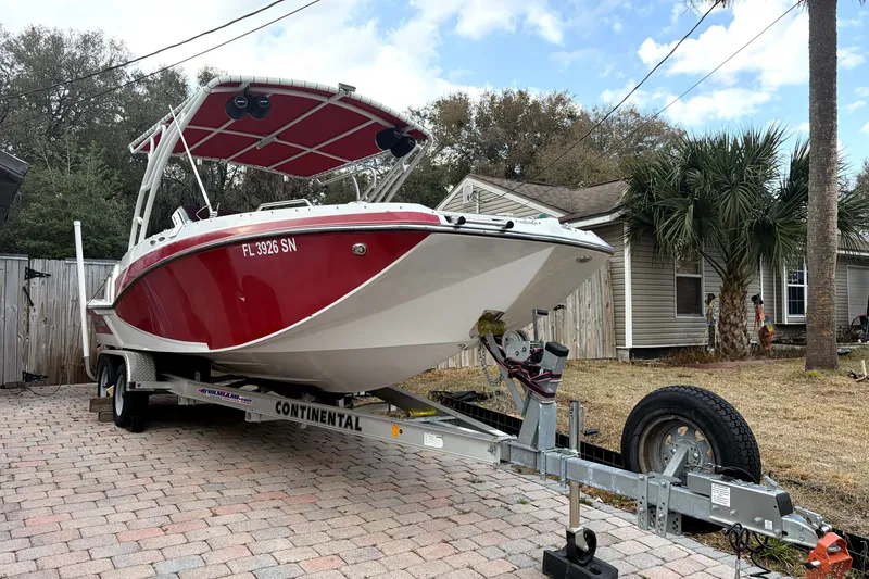 The Image of 2019 Glastron GTD 220 boat on trailer, parked in a residential driveway. - 0