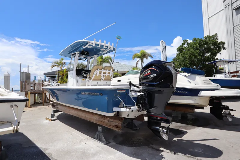 Slide: The Image of 2022 Sportsman Masters 247 Bay Boat with Yamaha engine, docked outdoors under blue sky. - 2