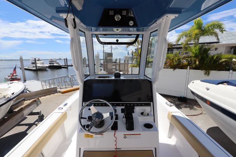 Slide: The Image of 2022 Sportsman Masters 247 Bay Boat cockpit with steering wheel, docked near marina. - 17