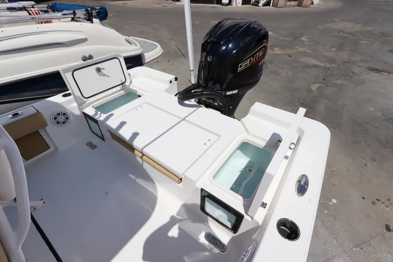 Slide: The Image of 2022 Sportsman Masters 247 Bay Boat with outboard motor and storage compartments. - 11
