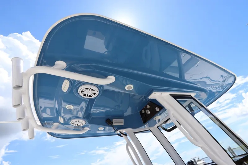 Slide: The Image of 2022 Sportsman Masters 247 Bay Boat T-top with speakers against blue sky. - 22
