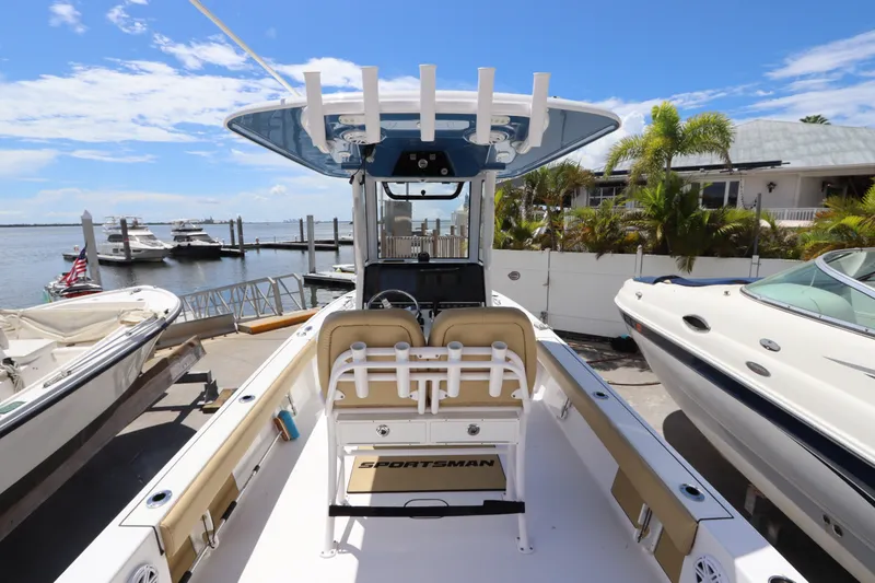 Slide: The Image of 2022 Sportsman Masters 247 Bay Boat docked, showcasing spacious deck and seating, with marina backdrop. - 13