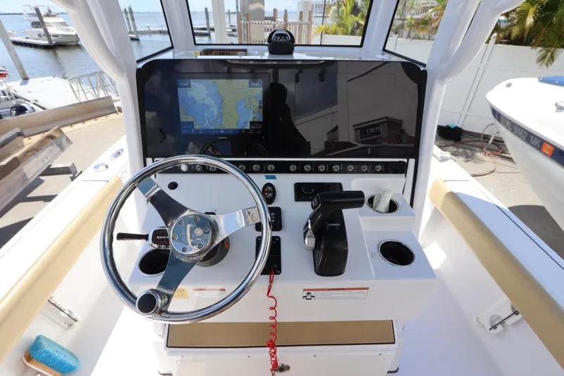 Slide: The Image of 2022 Sportsman Masters 247 Bay Boat helm with steering wheel and navigation display. - 18