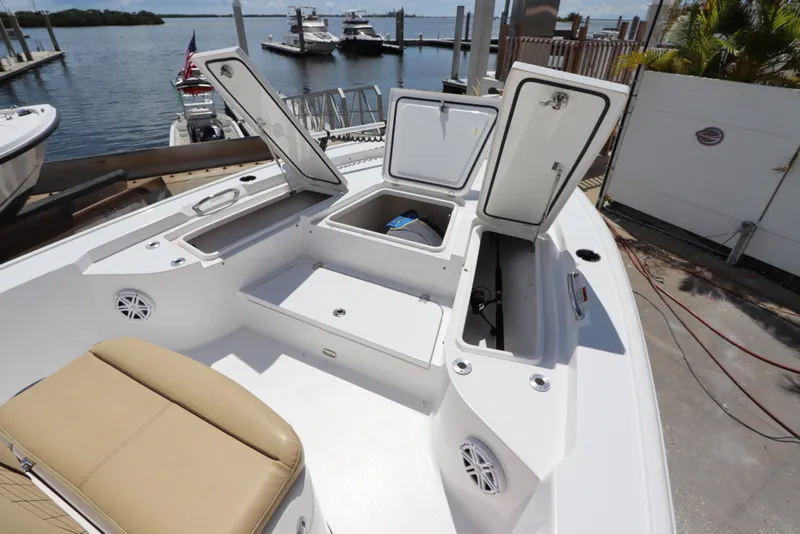 Slide: The Image of 2022 Sportsman Masters 247 Bay Boat with open storage compartments at a marina. - 28