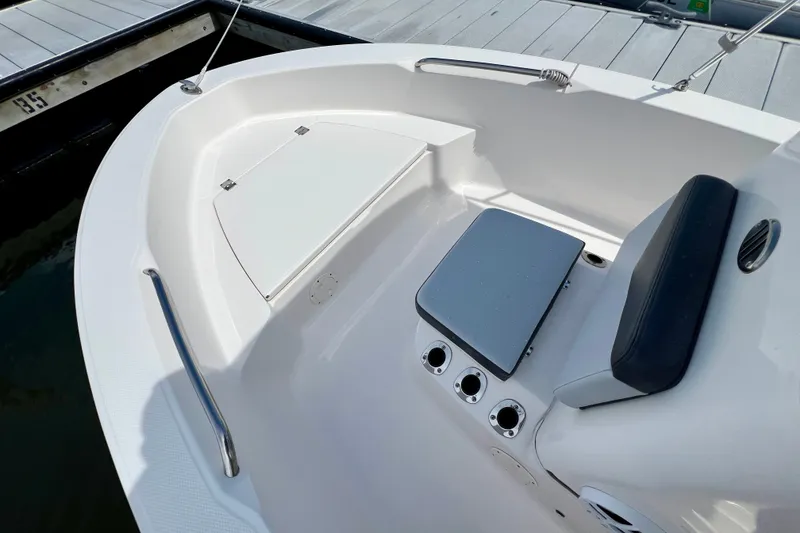 Slide: The Image of 2025 Robalo R160 Center Console boat interior with seating and storage at dock. - 9