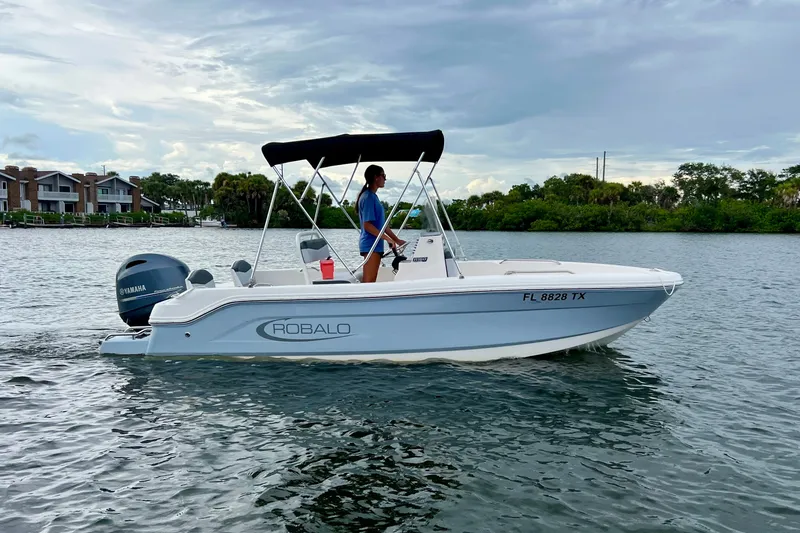 Slide: The Image of 2025 Robalo R160 Center Console boat cruising on a calm waterway. - 2