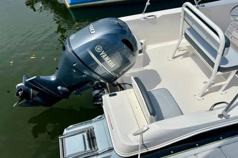 Slide: The Image of 2025 Robalo R160 Center Console boat with Yamaha 90 engine, docked on calm water. - 5