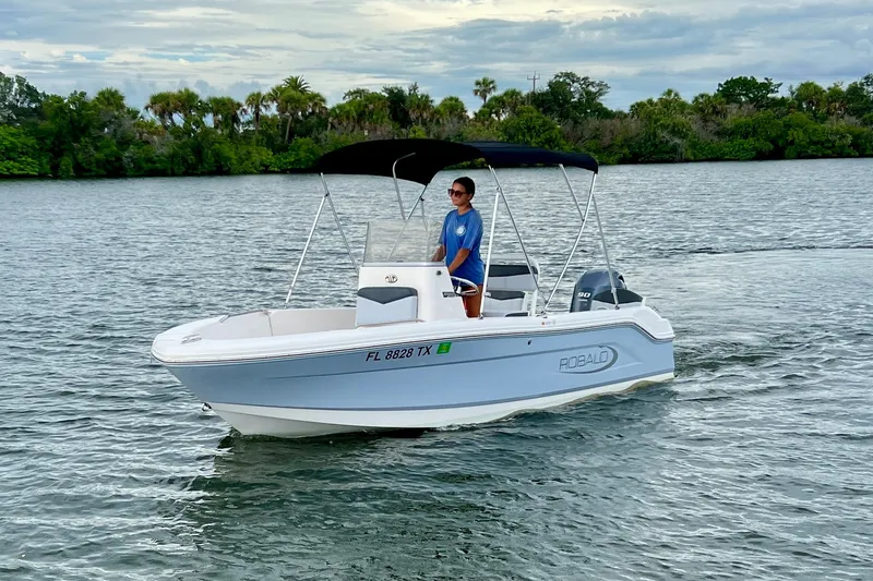 The Image of 2025 Robalo R160 Center Console boat cruising on a scenic waterway. - 0