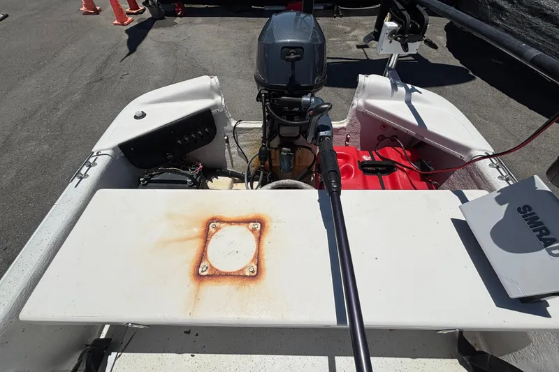 Slide: The Image of Een Carolina Skiff JV15TH boot met buitenboordmotor en console, geparkeerd op een trailer. - 18