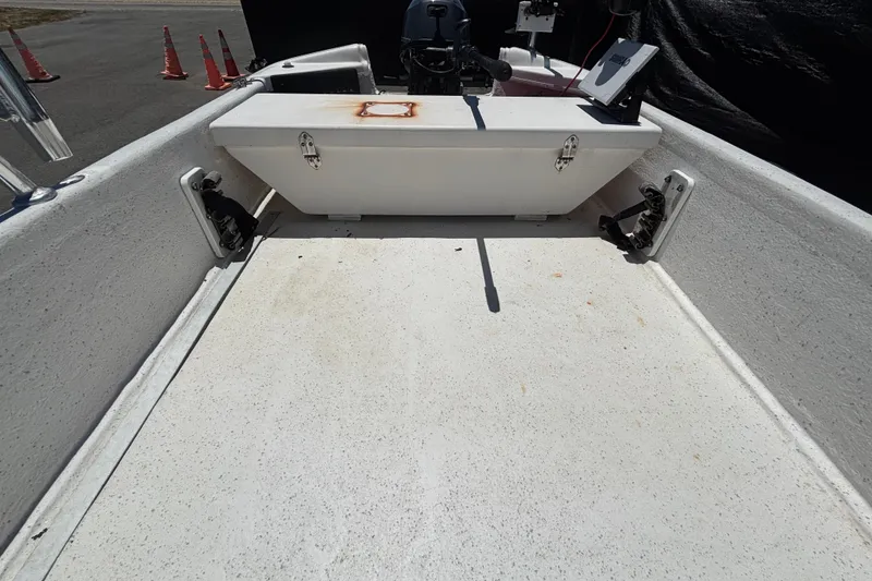 Slide: The Image of 2010 Carolina Skiff JV15TH boat interior with storage compartment and motor controls. - 17