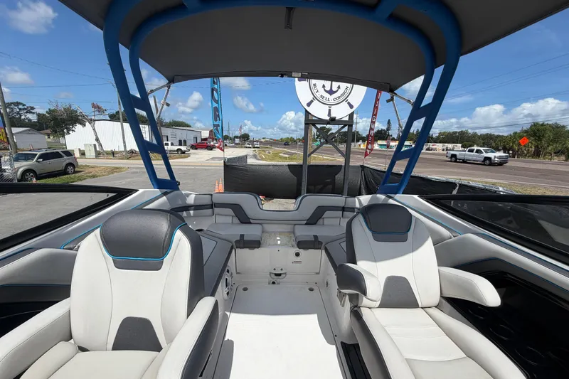 Slide: The Image of 2020 Yamaha AR240 boat interior with seating and canopy, parked outdoors. - 50