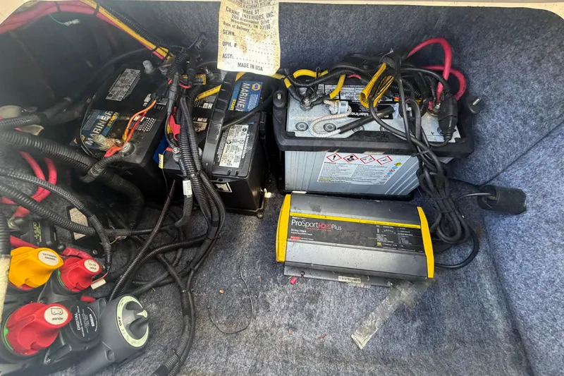 Slide: The Image of Battery compartment of a 2020 Yamaha AR240 boat with wiring and charger. - 59