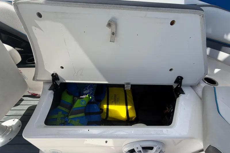 Slide: The Image of Open storage compartment on 2020 Yamaha AR240 boat with life jackets inside. - 53