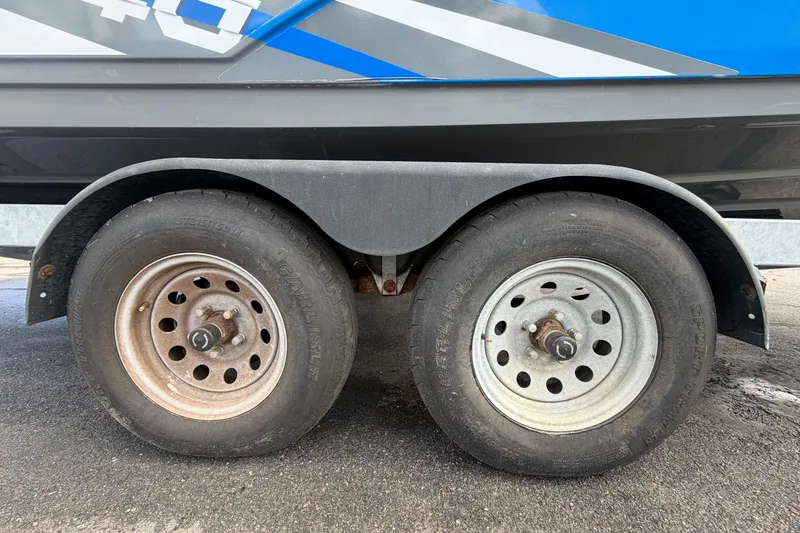 Slide: The Image of Trailer wheels of a 2020 Yamaha Boats AR240 on asphalt surface. - 69