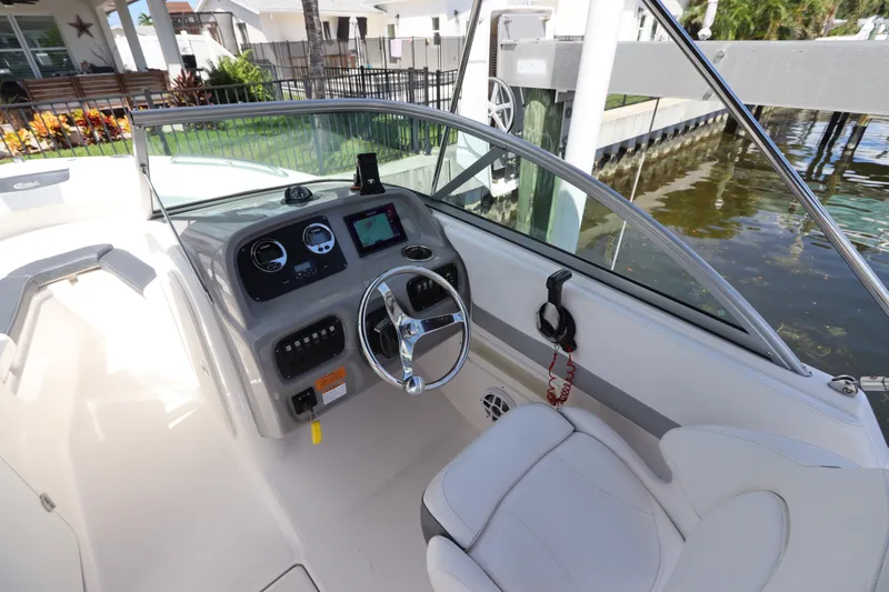 Slide: The Image of 2021 Robalo R227 Dual Console boat cockpit with steering wheel and dashboard controls. - 19
