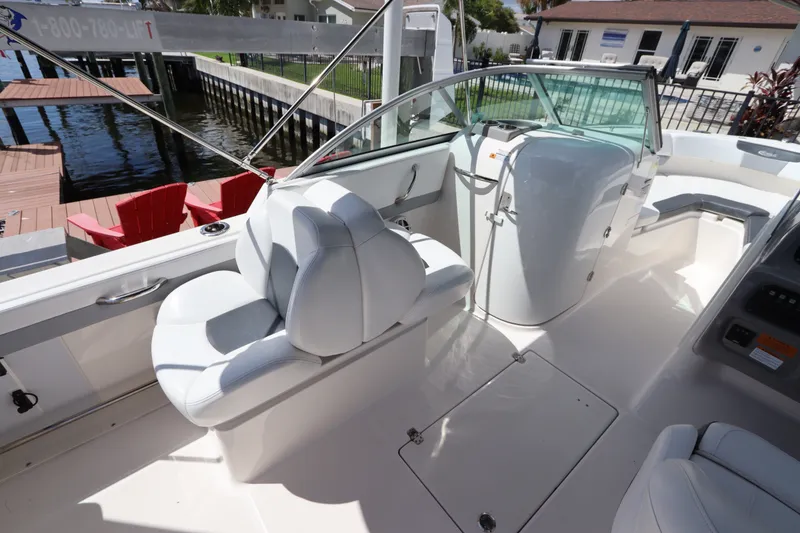 Slide: The Image of 2021 Robalo R227 Dual Console boat interior with white seating and helm. - 11