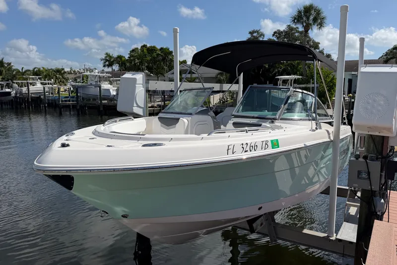 Slide: The Image of 2021 Robalo R227 Dual Console boat docked on a sunny day, featuring sleek design and canopy. - 1