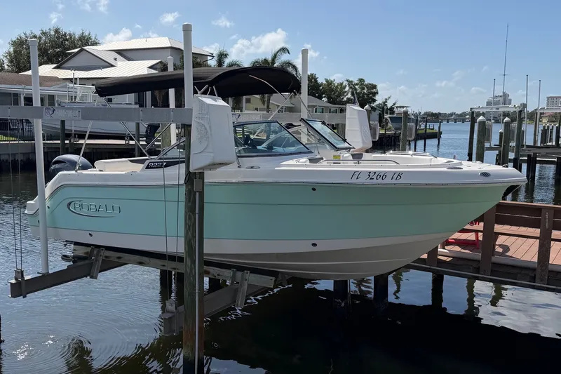The Image of 2021 Robalo R227 Dual Console boat docked at marina, featuring sleek design and mint green hull. - 0