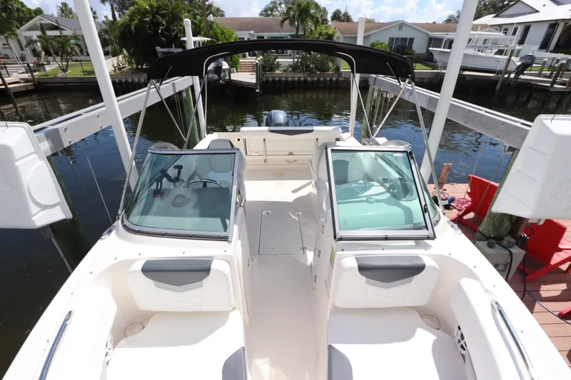 Slide: The Image of 2021 Robalo R227 Dual Console boat docked, featuring spacious seating and sleek design. - 25