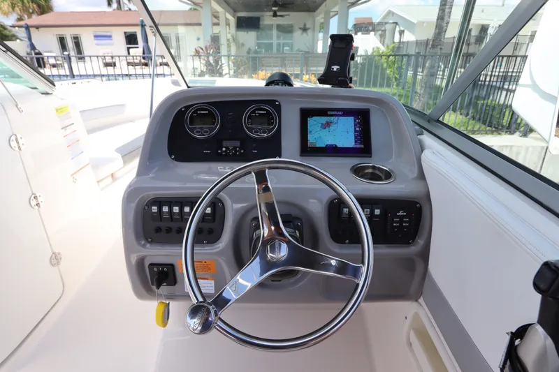 Slide: The Image of 2021 Robalo R227 Dual Console helm with steering wheel and navigation display. - 21