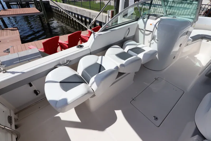 Slide: The Image of 2021 Robalo R227 Dual Console boat interior with white seating and waterfront view. - 12