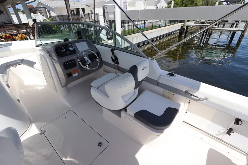 Slide: The Image of 2021 Robalo R227 Dual Console boat interior with steering wheel and seating. - 16