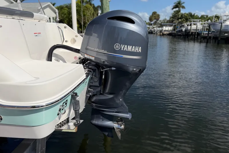 Slide: The Image of 2021 Robalo R227 Dual Console with Yamaha outboard motor on a calm waterway. - 7
