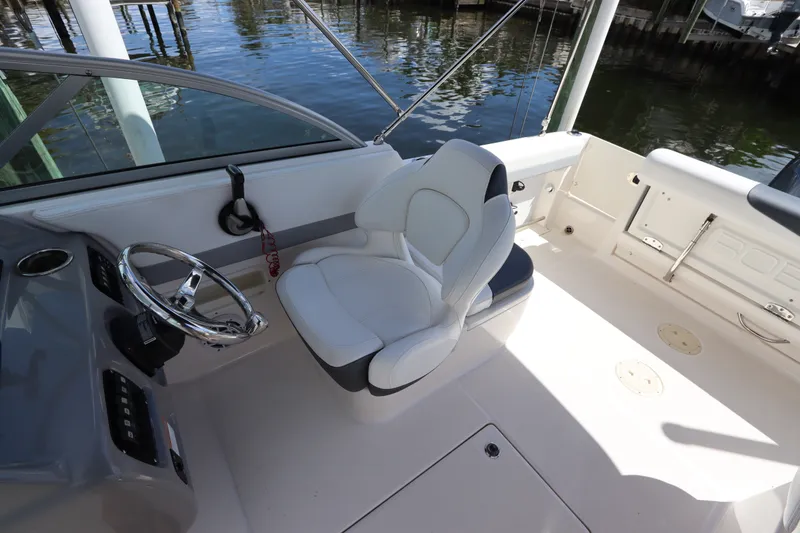 Slide: The Image of 2021 Robalo R227 Dual Console boat interior with steering wheel and seating. - 18