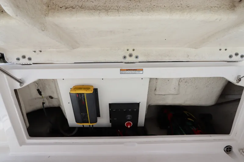 Slide: The Image of 2021 Robalo R227 Dual Console boat battery compartment with charger and wiring. - 9