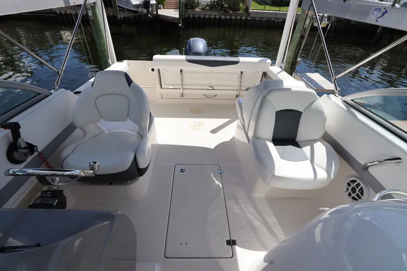 Slide: The Image of 2021 Robalo R227 Dual Console boat interior with seating and steering wheel. - 2