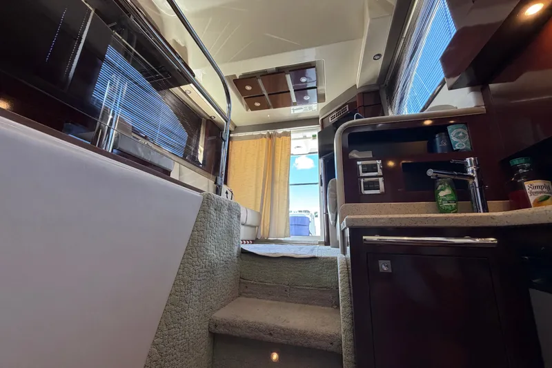 Slide: The Image of Interior view of 2010 Sea Ray 390 Sedan Bridge yacht, featuring stairs and kitchenette. - 94