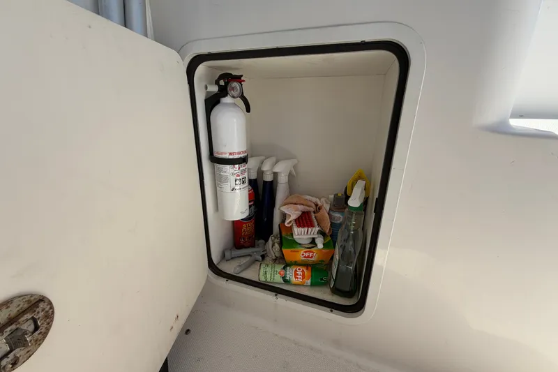 Slide: The Image of Storage compartment on 2010 Sea Ray 390 Sedan Bridge with cleaning supplies and fire extinguisher. - 26