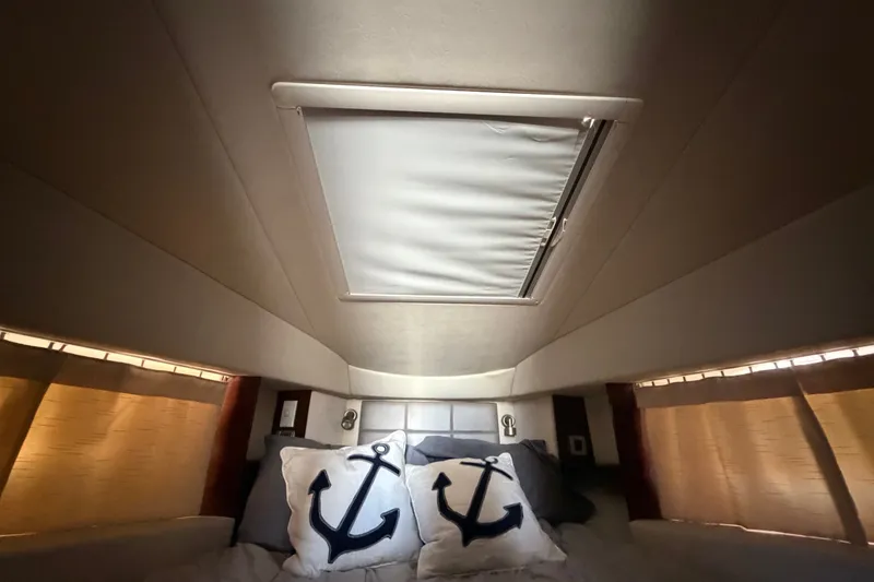 Slide: The Image of Cozy cabin interior of 2010 Sea Ray 390 Sedan Bridge with nautical-themed pillows. - 102