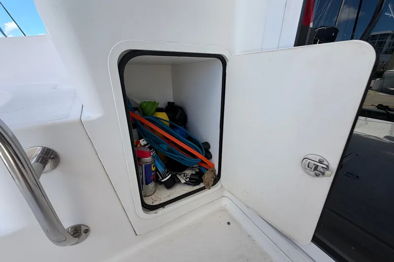 Slide: The Image of Open storage compartment on 2010 Sea Ray 390 Sedan Bridge, containing various boating supplies. - 24