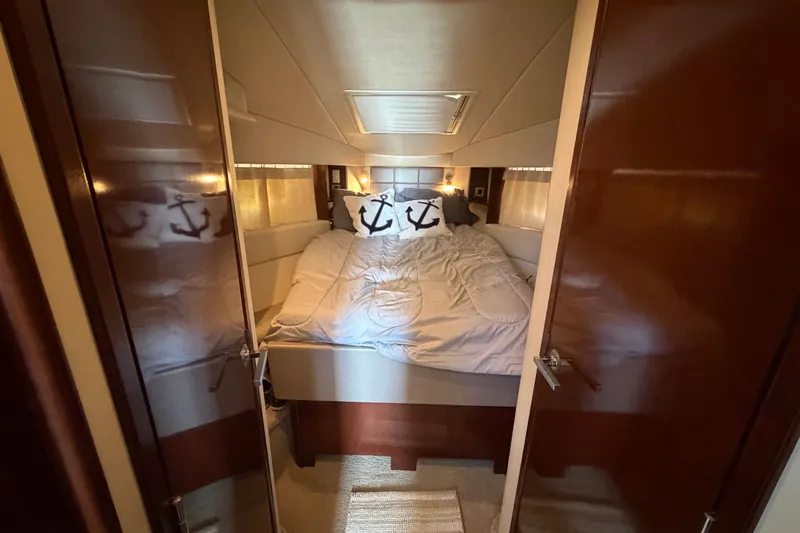 Slide: The Image of Cozy bedroom interior of 2010 Sea Ray 390 Sedan Bridge with nautical-themed decor. - 99