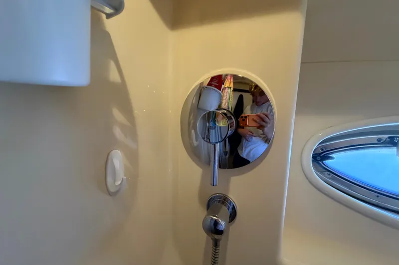 Slide: The Image of Interior of 2010 Sea Ray 390 Sedan Bridge bathroom with mirror and porthole window. - 116