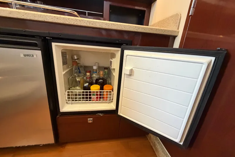 Slide: The Image of Mini fridge stocked with beverages on a 2010 Sea Ray 390 Sedan Bridge yacht. - 68