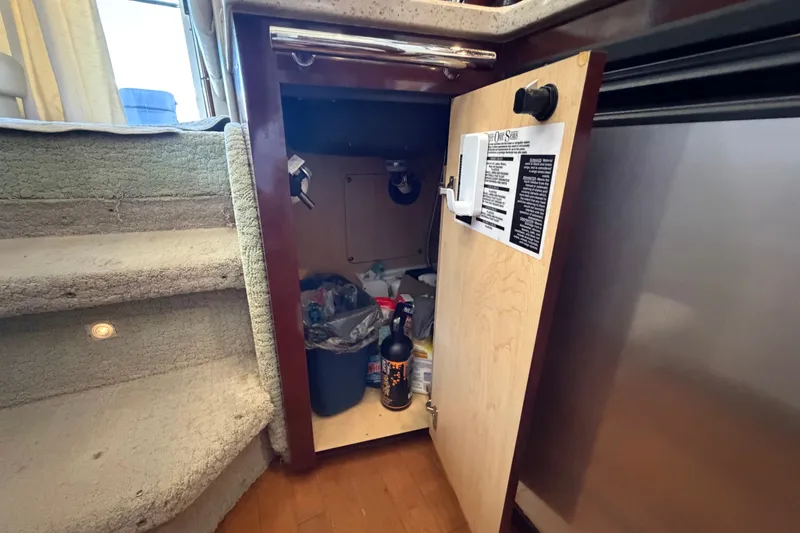 Slide: The Image of Open cabinet on 2010 Sea Ray 390 Sedan Bridge, revealing storage and cleaning supplies. - 81
