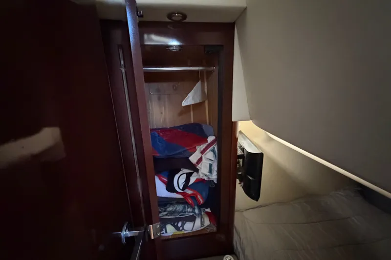 Slide: The Image of Interior closet of 2010 Sea Ray 390 Sedan Bridge with folded clothes. - 128