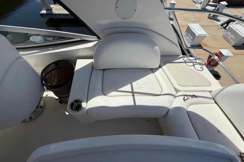 Slide: The Image of 2010 Sea Ray 390 Sedan Bridge interior seating area with cup holder and dock view. - 34