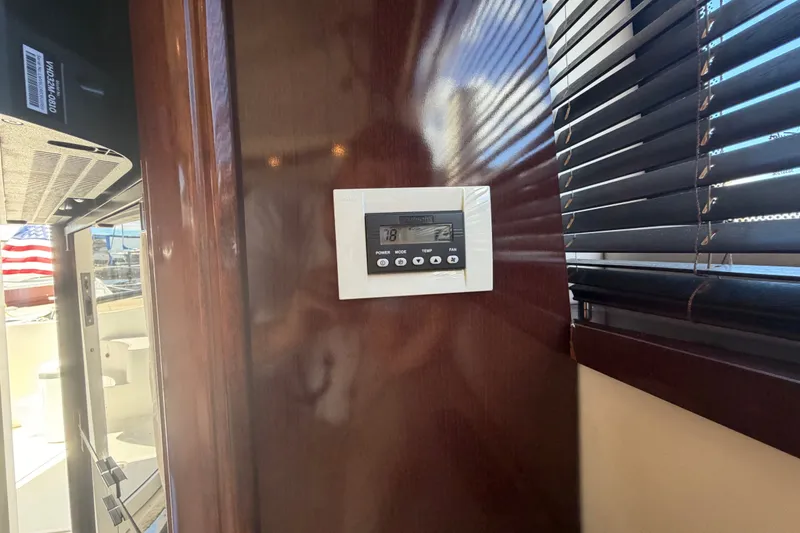 Slide: The Image of Thermostat on 2010 Sea Ray 390 Sedan Bridge yacht interior with wooden paneling and blinds. - 87
