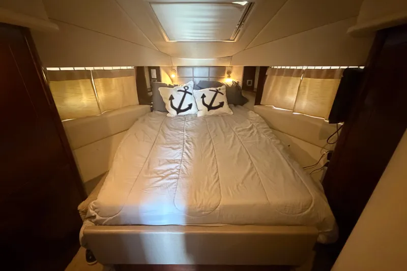Slide: The Image of Luxurious bedroom interior of 2010 Sea Ray 390 Sedan Bridge yacht with nautical-themed pillows. - 100
