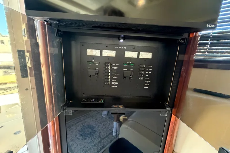 Slide: The Image of Electrical panel inside 2010 Sea Ray 390 Sedan Bridge yacht, featuring control switches and meters. - 84