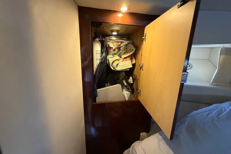 Slide: The Image of Cabinet interior on 2010 Sea Ray 390 Sedan Bridge, storing blankets and equipment. - 105