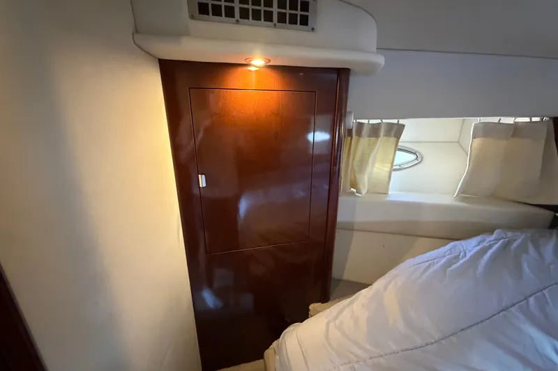 Slide: The Image of Interior cabin of 2010 Sea Ray 390 Sedan Bridge with wooden cabinet and porthole window. - 104